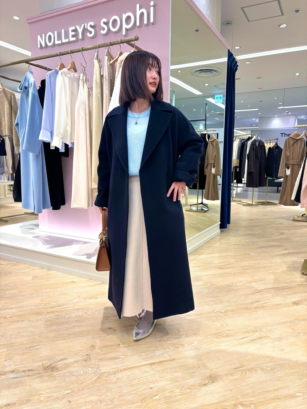 ベージュ系のスカート、ブルー系のニット/セーター、ブルー系のその他アウターを着用したレディースの冬コーディネートの2枚目の写真