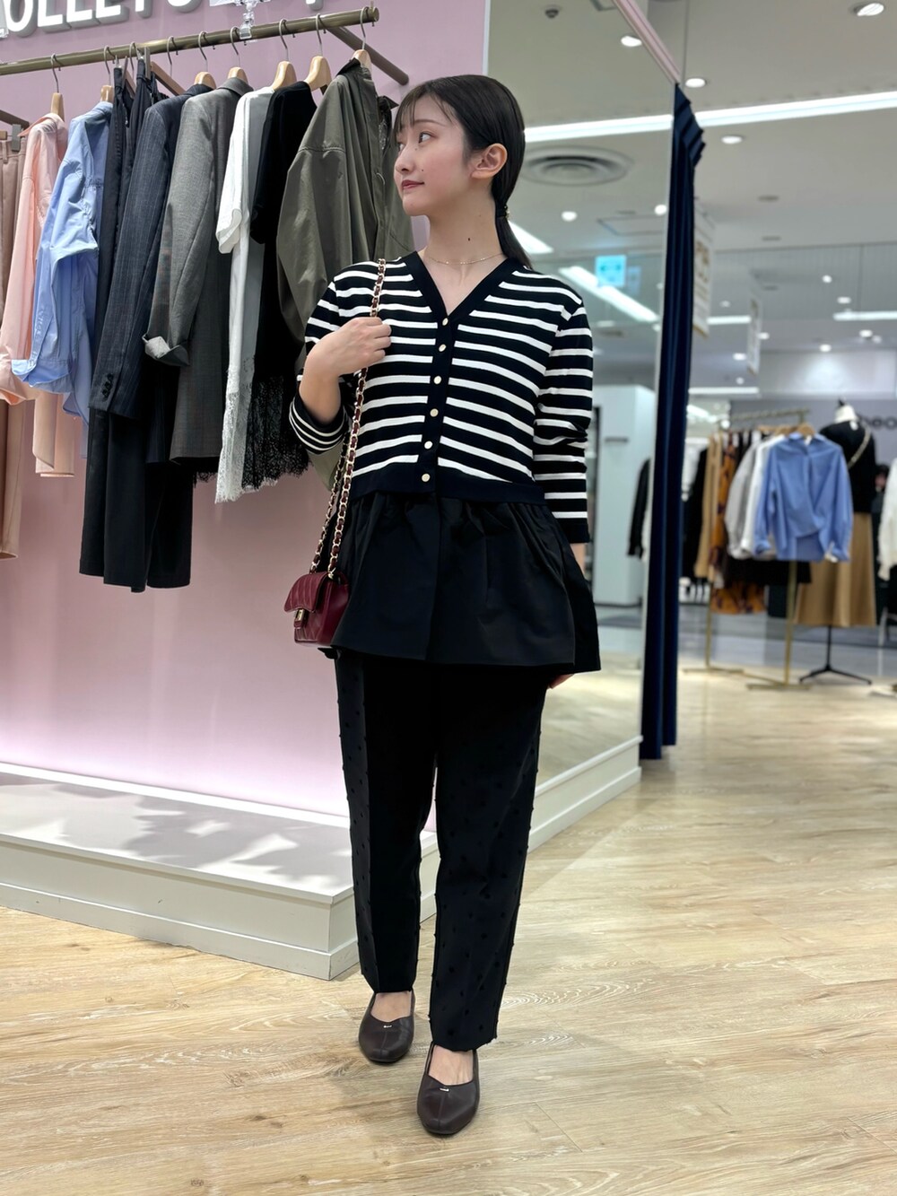 ブラック系のカーディガン/ボレロ、ブラック系のその他パンツ、レッド系のショルダーバッグを着用したレディースの秋コーディネートの2枚目の写真
