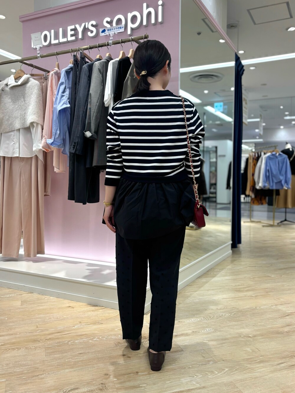 ブラック系のカーディガン/ボレロ、ブラック系のその他パンツ、レッド系のショルダーバッグを着用したレディースの秋コーディネートの4枚目の写真