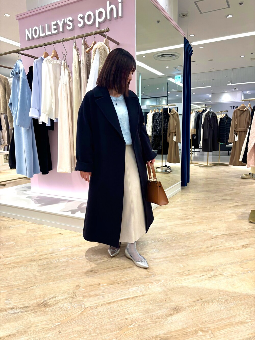 ベージュ系のスカート、ブルー系のニット/セーター、ブルー系のその他アウターを着用したレディースの冬コーディネートの6枚目の写真