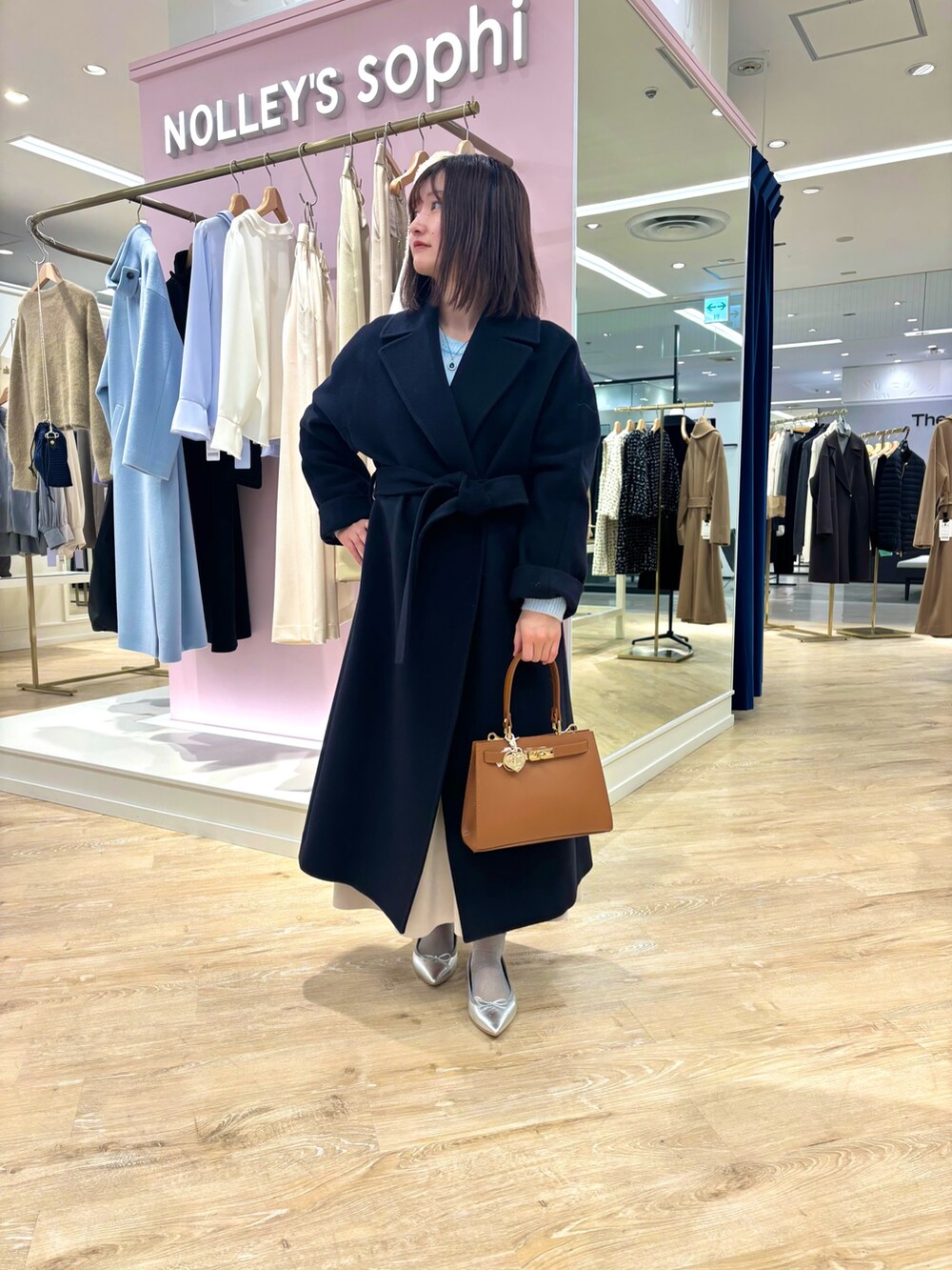 ベージュ系のスカート、ブルー系のニット/セーター、ブルー系のその他アウターを着用したレディースの冬コーディネートの8枚目の写真