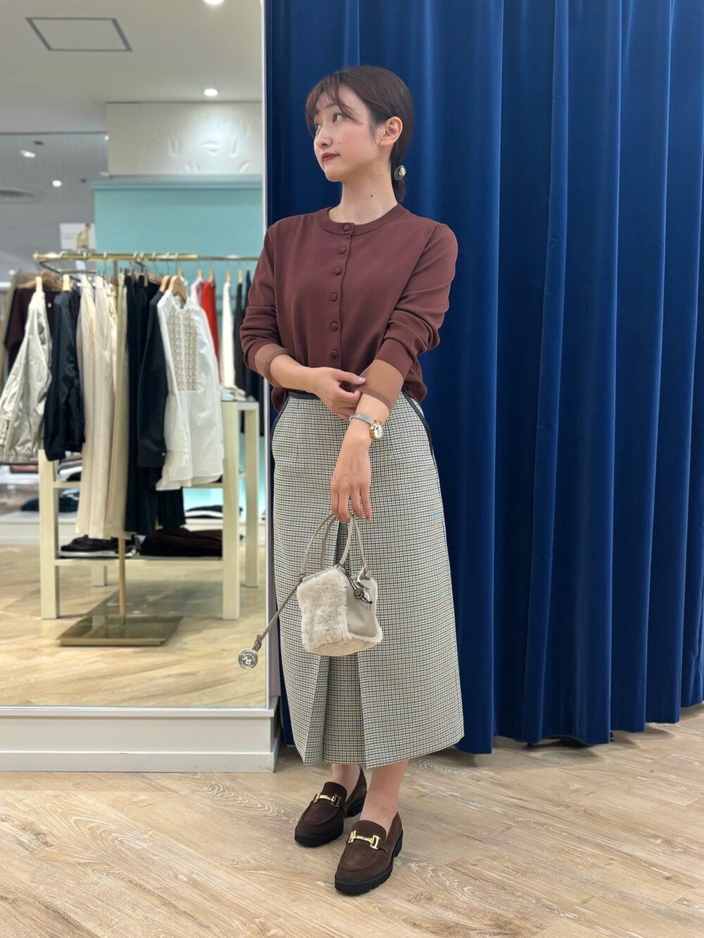 ブラック系のスカート、ベージュ系のショルダーバッグ、ブラウン系のカーディガン/ボレロを着用したレディースの秋コーディネートの5枚目の写真