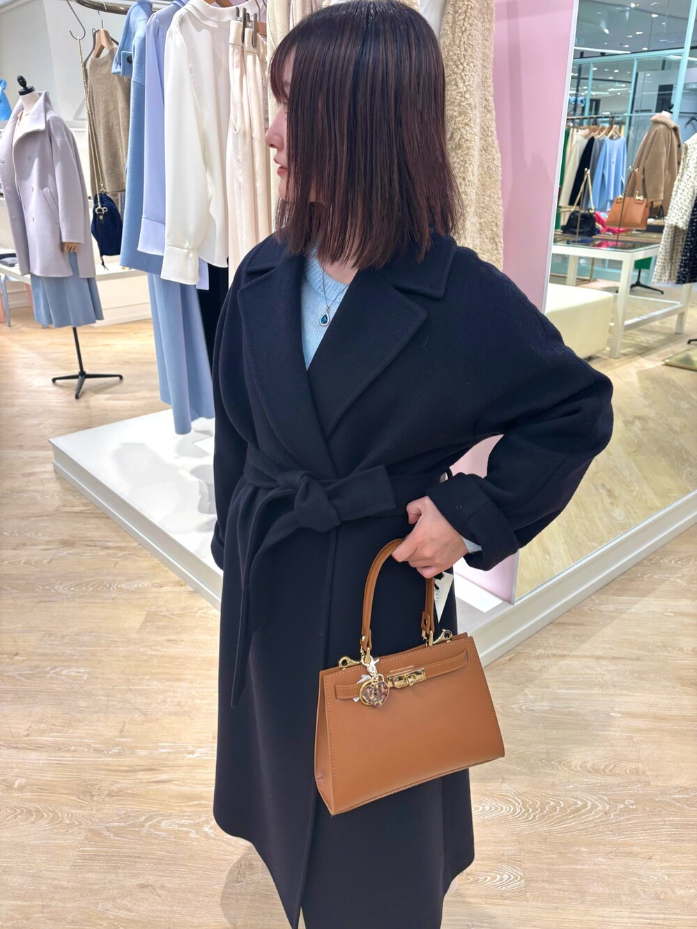 ベージュ系のスカート、ブルー系のニット/セーター、ブルー系のその他アウターを着用したレディースの冬コーディネートの9枚目の写真