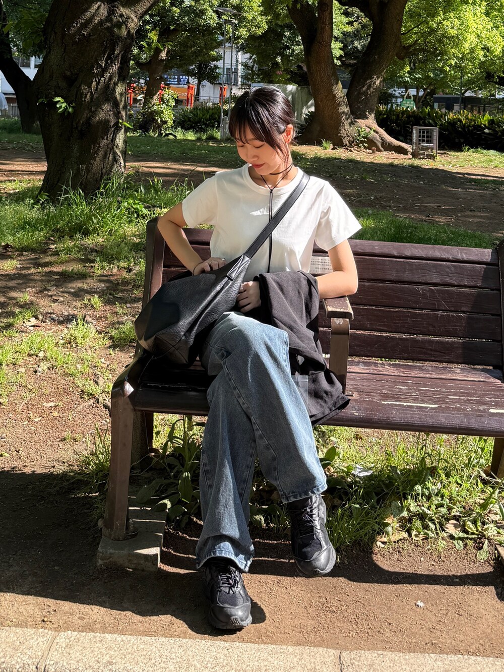 ホワイト系のTシャツ/カットソー、ブルー系のデニムパンツ、ブラック系のショルダーバッグを着用したレディースの夏コーディネートの4枚目の写真