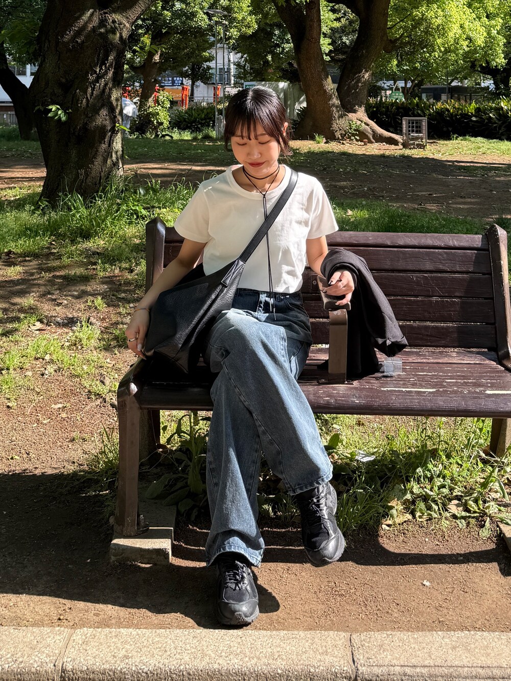 ホワイト系のTシャツ/カットソー、ブルー系のデニムパンツ、ブラック系のショルダーバッグを着用したレディースの夏コーディネートの3枚目の写真
