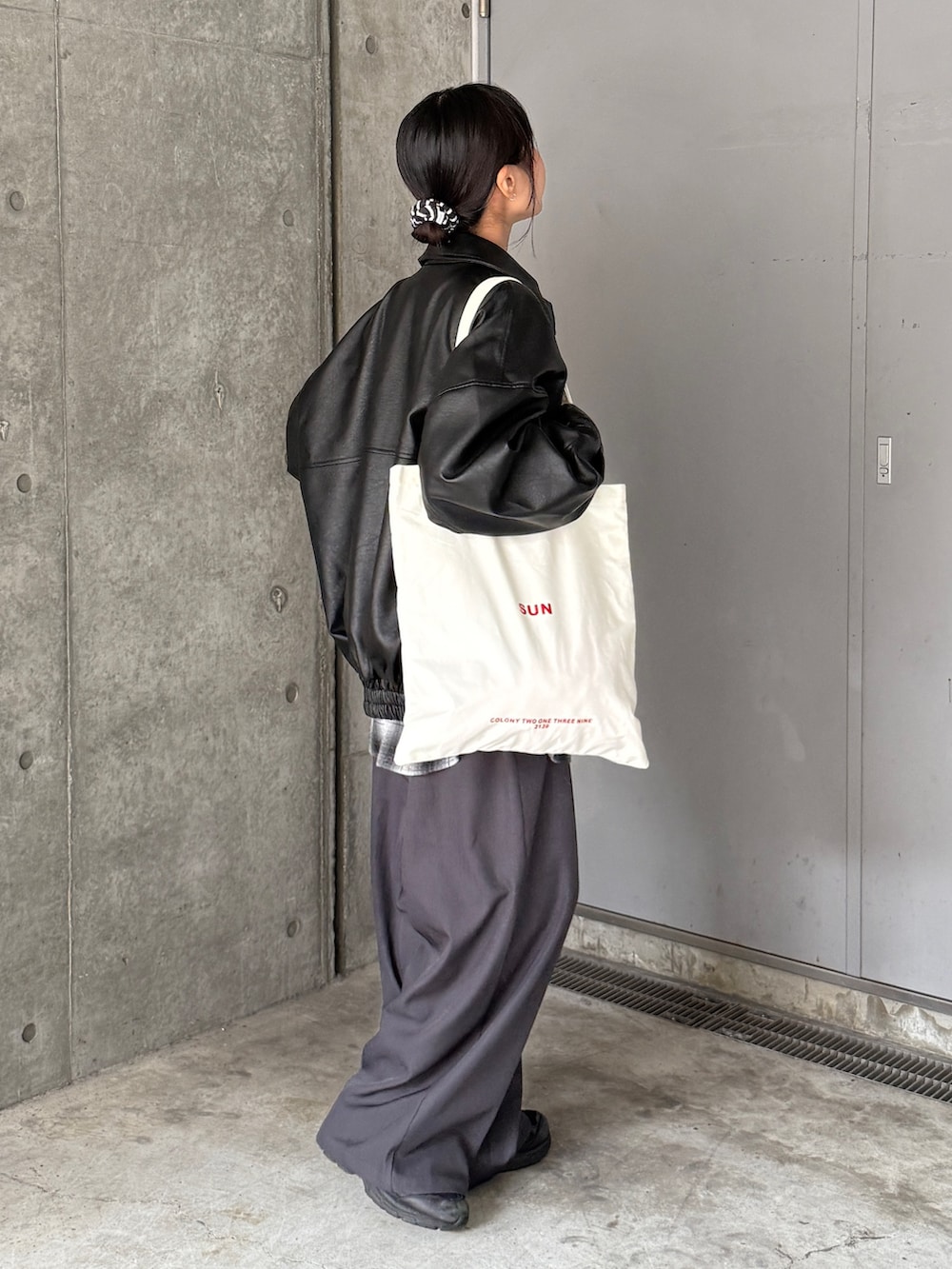 ブラック系のライダースジャケット、ブラック系のシャツ/ブラウス、グレー系のスラックスを着用したレディースの秋コーディネートの2枚目の写真