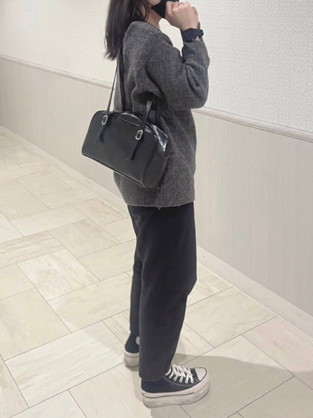 グレー系のニット/セーター、ブラック系のパンツ、ブラック系のスニーカーを着用したレディースの春コーディネートの3枚目の写真