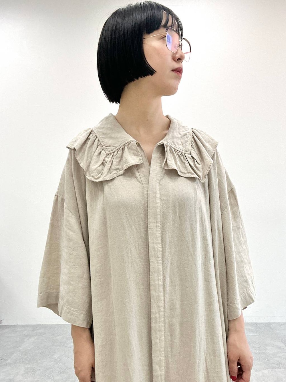 ベージュ系のワンピースを着用したレディースの夏コーディネートの2枚目の写真