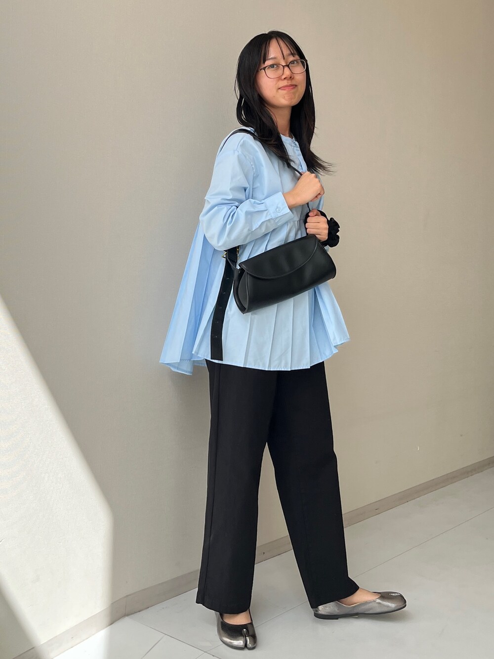 ブラック系のパンツ、シルバー系のパンプスを着用したレディースの秋コーディネートの2枚目の写真