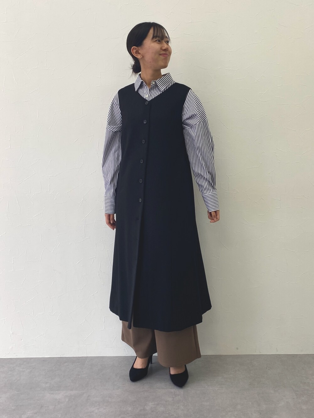 ブルー系のシャツ/ブラウス、ブラウン系のその他パンツ、ブラック系のフォーマルスーツ/小物を着用したレディースの秋コーディネートの2枚目の写真