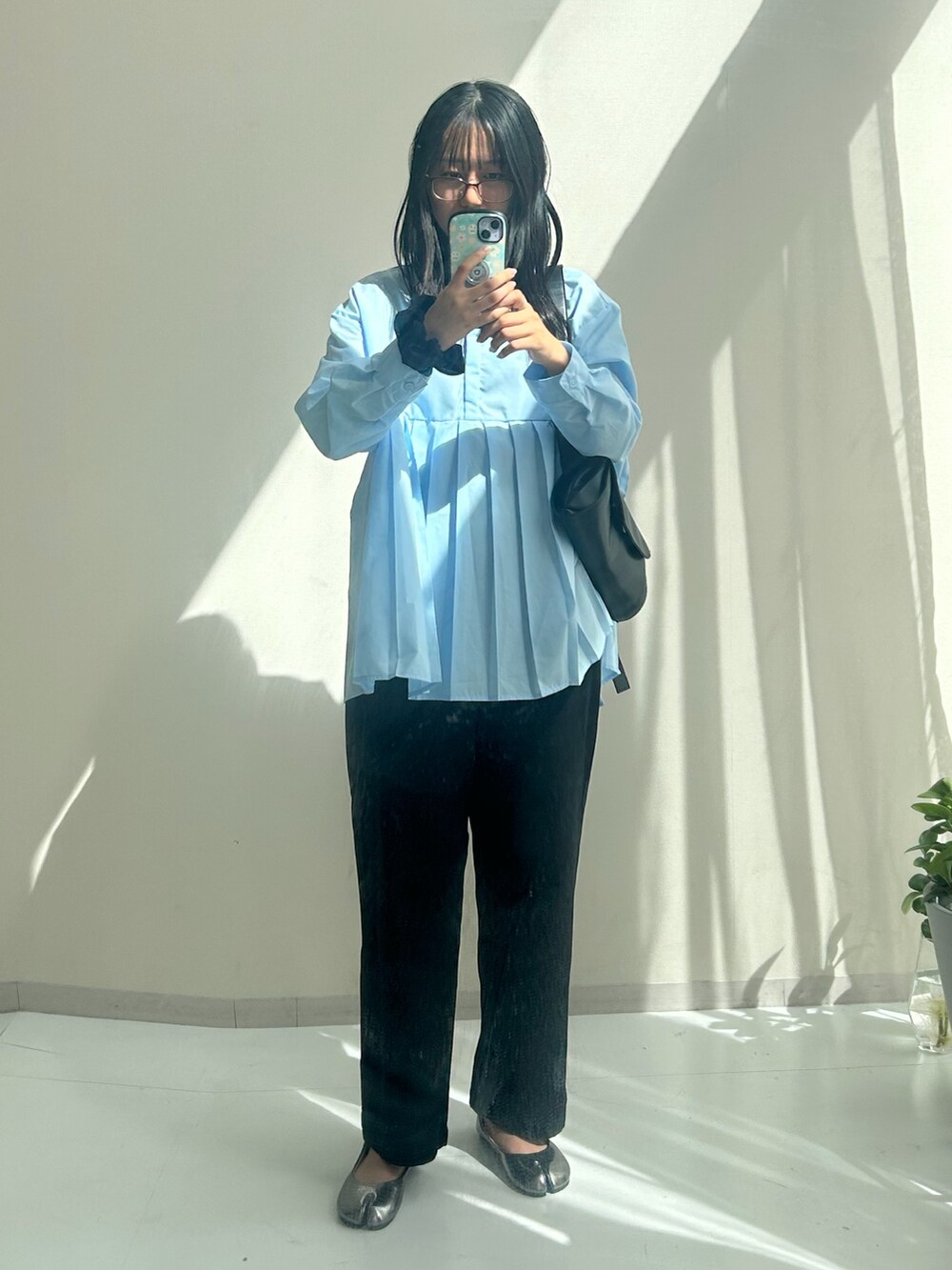 ブラック系のパンツ、シルバー系のパンプスを着用したレディースの秋コーディネートの3枚目の写真