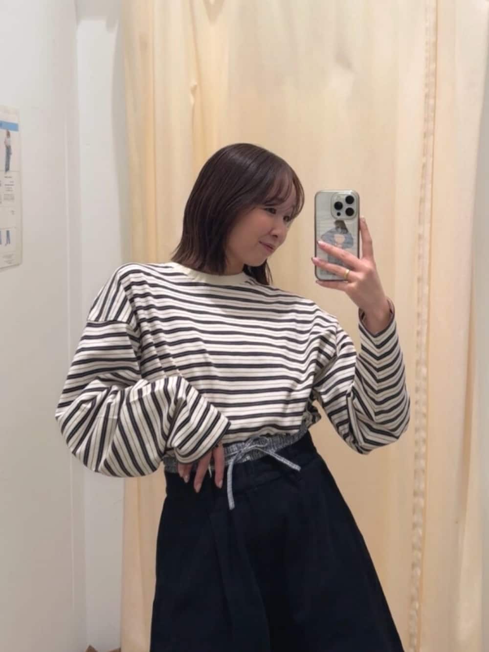 グレー系のトレンチコート、ブラック系のその他パンツ、ブラック系のブーツを着用したレディースの冬コーディネートの5枚目の写真