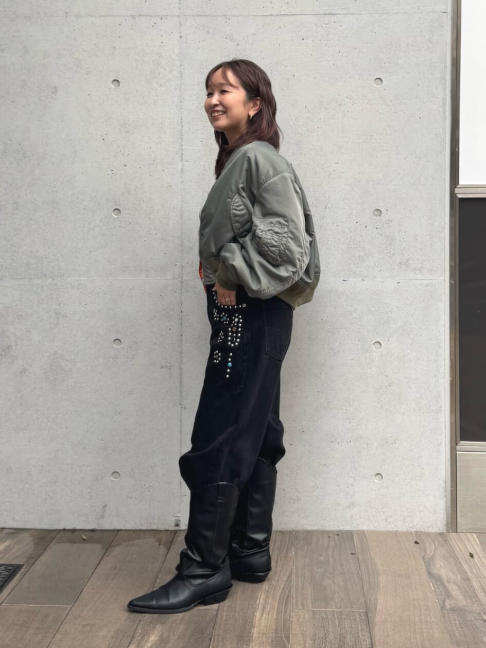 グリーン系のMA-1、ホワイト系のTシャツ/カットソー、ブラック系のデニムパンツを着用したレディースの秋コーディネートの2枚目の写真