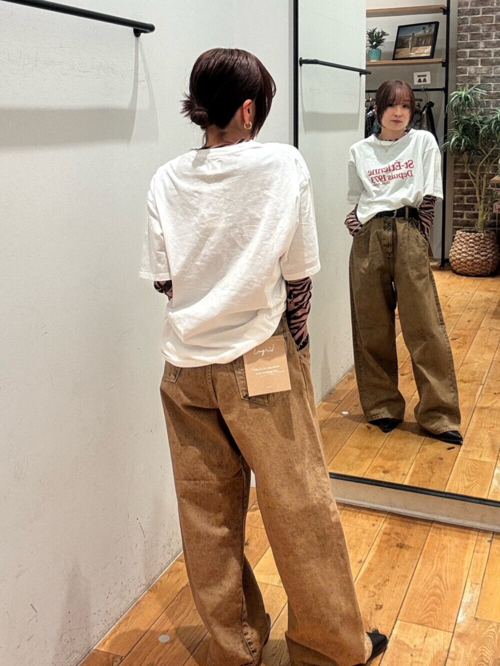 ホワイト系のTシャツ/カットソー、ブラック系のTシャツ/カットソー、ブラウン系のデニムパンツを着用したレディースの春コーディネートの3枚目の写真