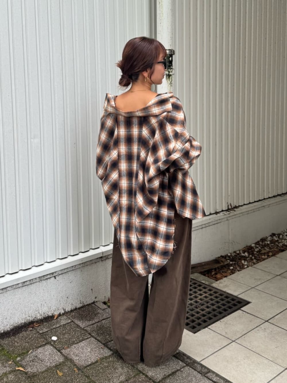 ブラウン系のデニムパンツ、ブラック系のブーツ、ブラウン系のシャツ/ブラウスを着用したレディースの夏コーディネートの3枚目の写真