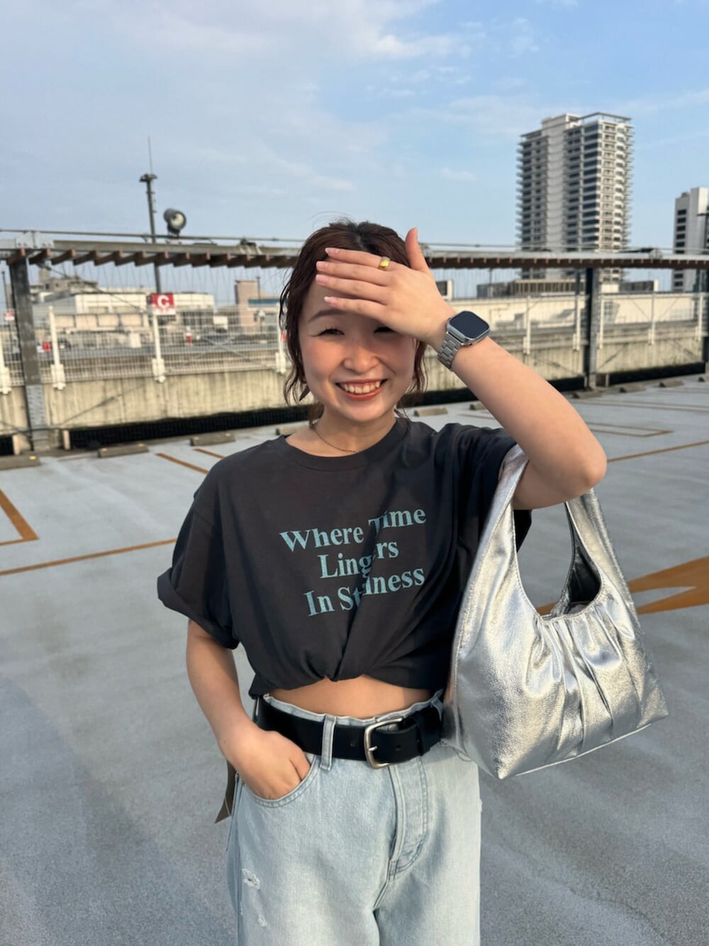 グレー系のTシャツ/カットソー、ブルー系のデニムパンツ、シルバー系のハンドバッグを着用したレディースの春コーディネートの4枚目の写真
