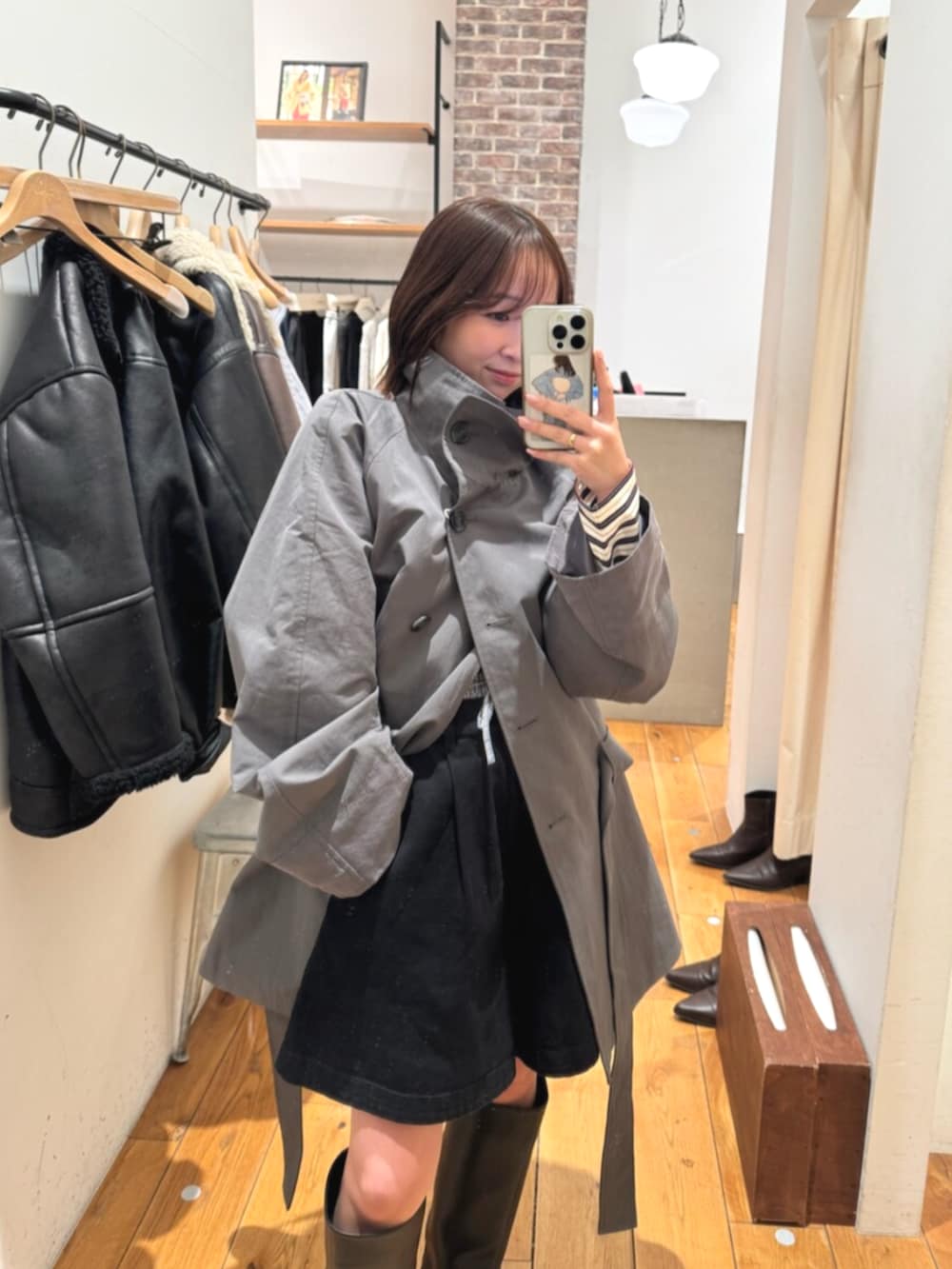 グレー系のトレンチコート、ブラック系のその他パンツ、ブラック系のブーツを着用したレディースの冬コーディネートの4枚目の写真