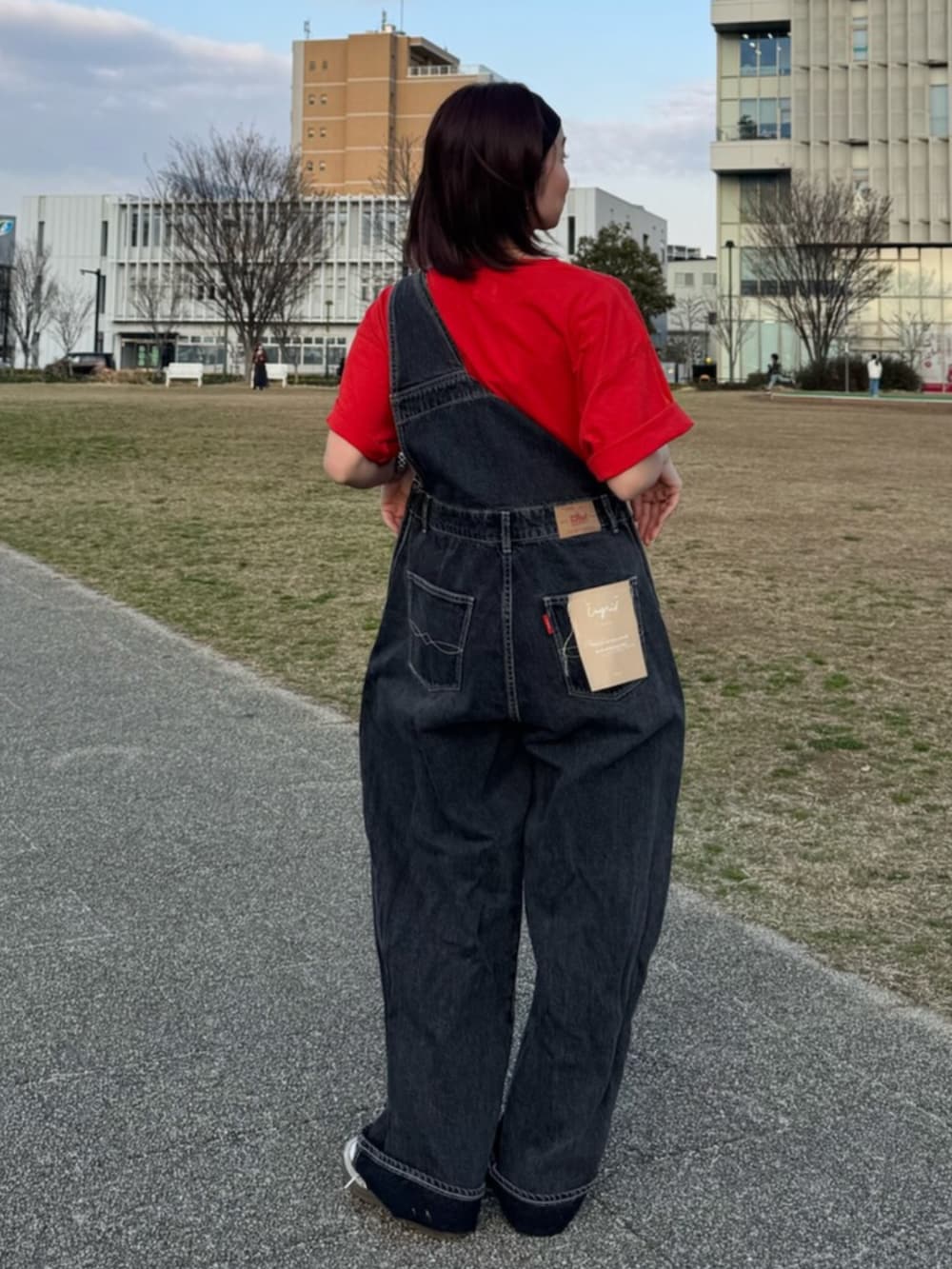 ブラック系のつなぎ/オールインワン、レッド系のTシャツ/カットソー、ブラック系のヘアバンドを着用したレディースの春コーディネートの3枚目の写真