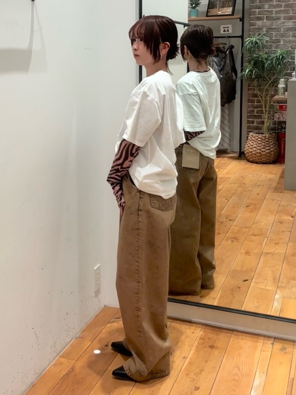 ホワイト系のTシャツ/カットソー、ブラック系のTシャツ/カットソー、ブラウン系のデニムパンツを着用したレディースの春コーディネートの2枚目の写真