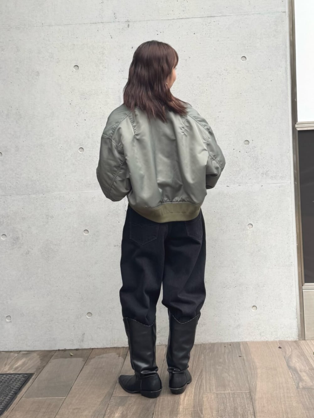 グリーン系のMA-1、ホワイト系のTシャツ/カットソー、ブラック系のデニムパンツを着用したレディースの秋コーディネートの3枚目の写真