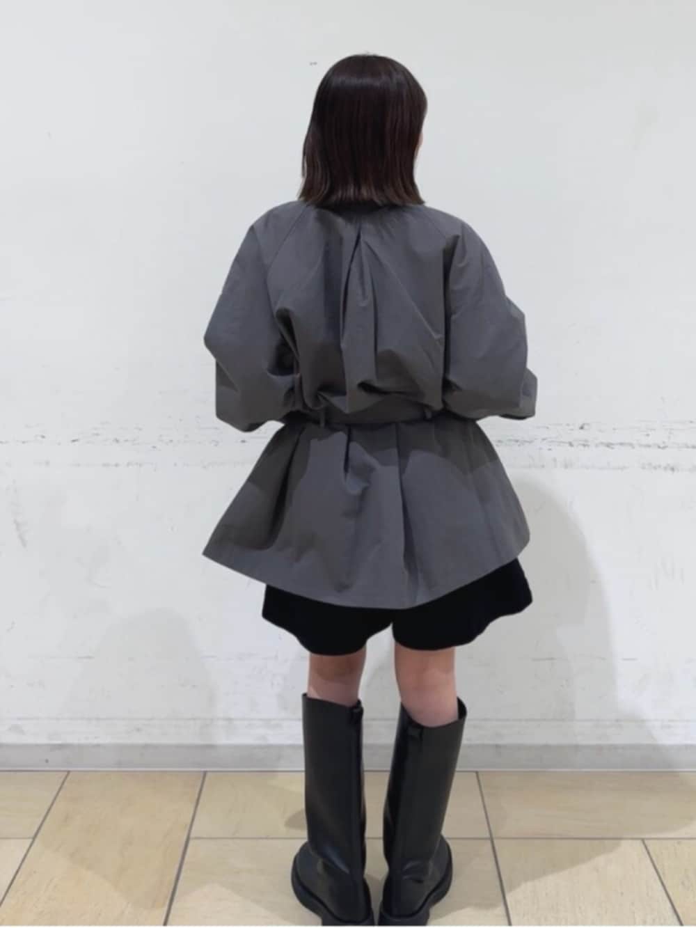 グレー系のトレンチコート、ブラック系のその他パンツ、ブラック系のブーツを着用したレディースの冬コーディネートの3枚目の写真