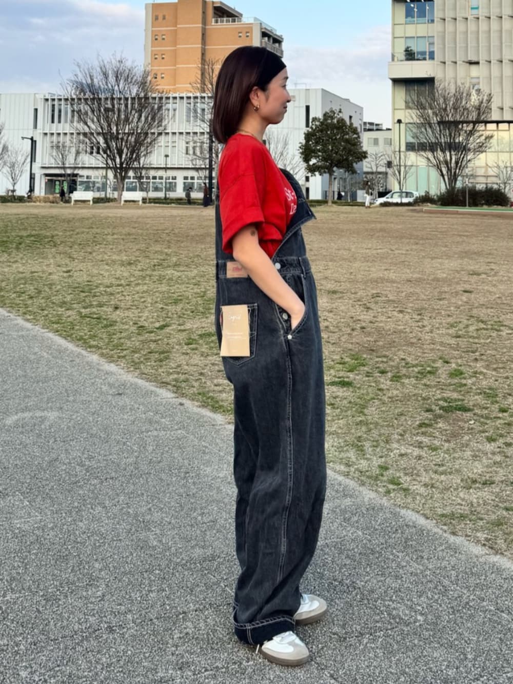 ブラック系のつなぎ/オールインワン、レッド系のTシャツ/カットソー、ブラック系のヘアバンドを着用したレディースの春コーディネートの2枚目の写真