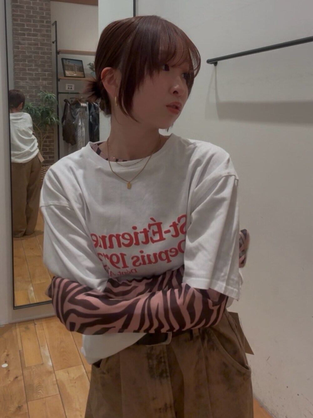 ホワイト系のTシャツ/カットソー、ブラック系のTシャツ/カットソー、ブラウン系のデニムパンツを着用したレディースの春コーディネートの4枚目の写真