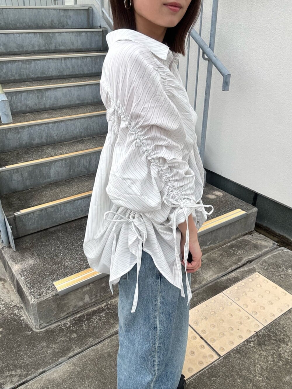 ブルー系のデニムパンツ、ホワイト系のシャツ/ブラウス、レッド系のキャップを着用したレディースの冬コーディネートの4枚目の写真