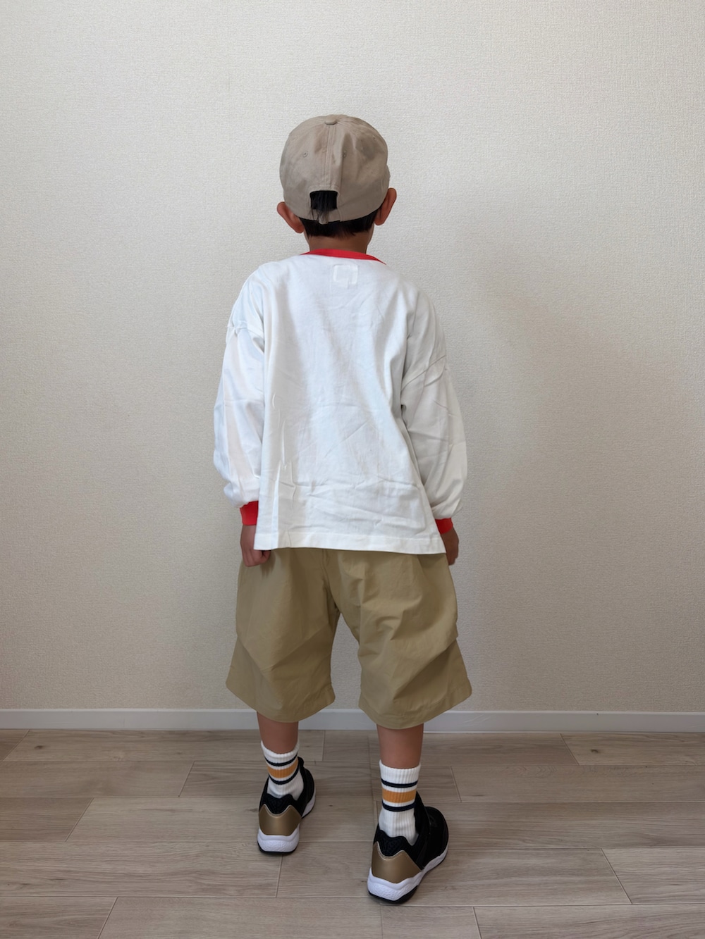 ホワイト系のTシャツ/カットソー、ベージュ系のその他パンツ、ブラック系のスニーカーを着用したキッズの春コーディネートの3枚目の写真