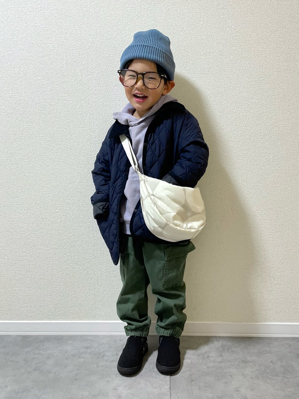 ブラック系のジャケット/アウター、ホワイト系のショルダーバッグ、パープル系のパーカーを着用したキッズの冬コーディネートの2枚目の写真