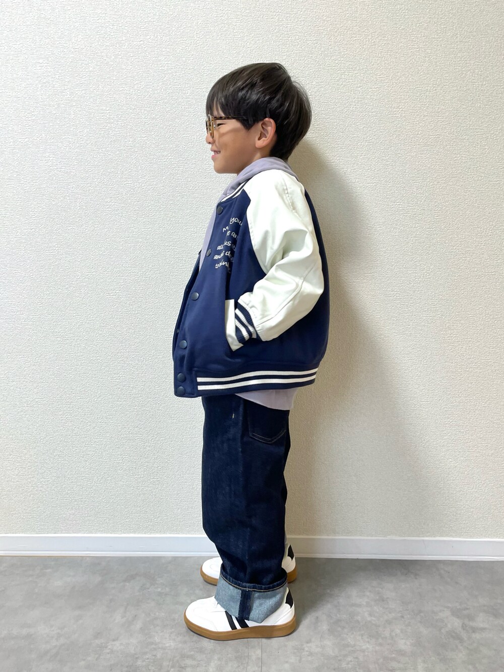 ブルー系のジャケット/アウター、ブルー系のデニムパンツ、ホワイト系のスニーカーを着用したキッズの秋コーディネートの2枚目の写真