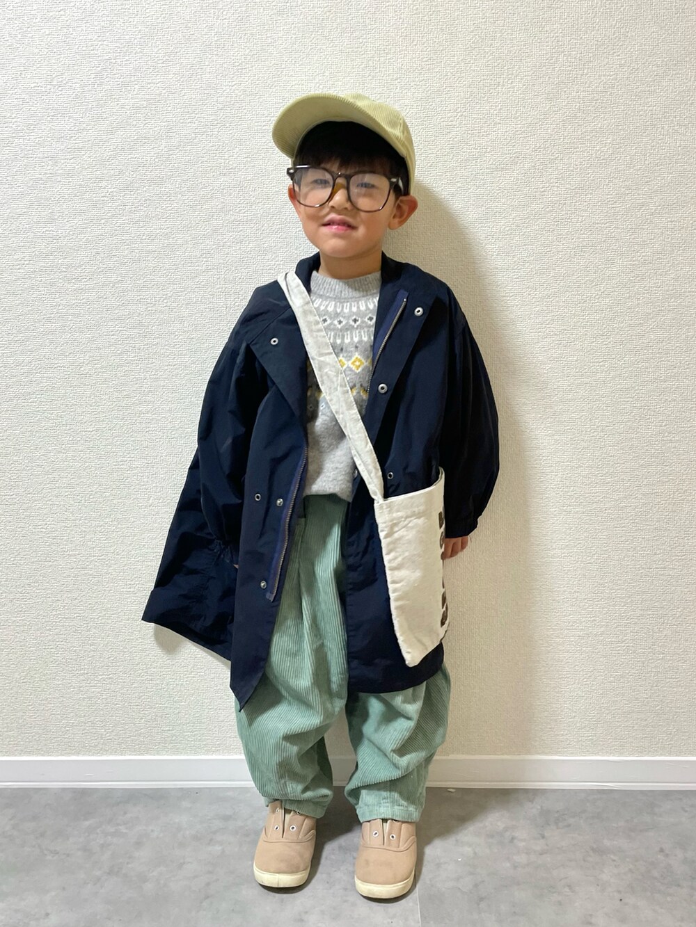 グリーン系のその他パンツ、ベージュ系のショルダーバッグ、グレー系のスニーカーを着用したキッズの冬コーディネートの2枚目の写真