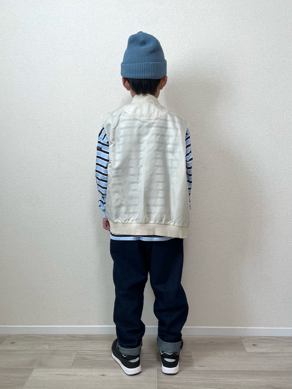 ベージュ系のベスト、ブルー系のTシャツ/カットソー、ブルー系のショルダーバッグを着用したキッズの冬コーディネートの3枚目の写真