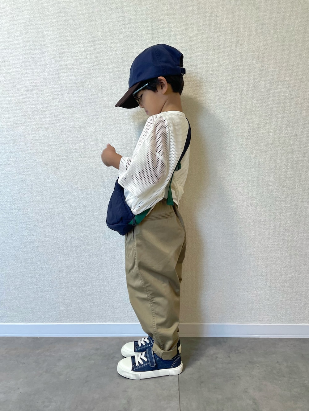 ブルー系のショルダーバッグ、ホワイト系のトップス、ベージュ系のチノパンツを着用したキッズの夏コーディネートの2枚目の写真