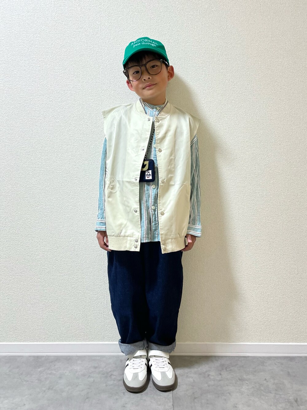 ベージュ系のベスト、グリーン系のシャツ/ブラウス、ブルー系のショルダーバッグを着用したキッズの春コーディネートの2枚目の写真