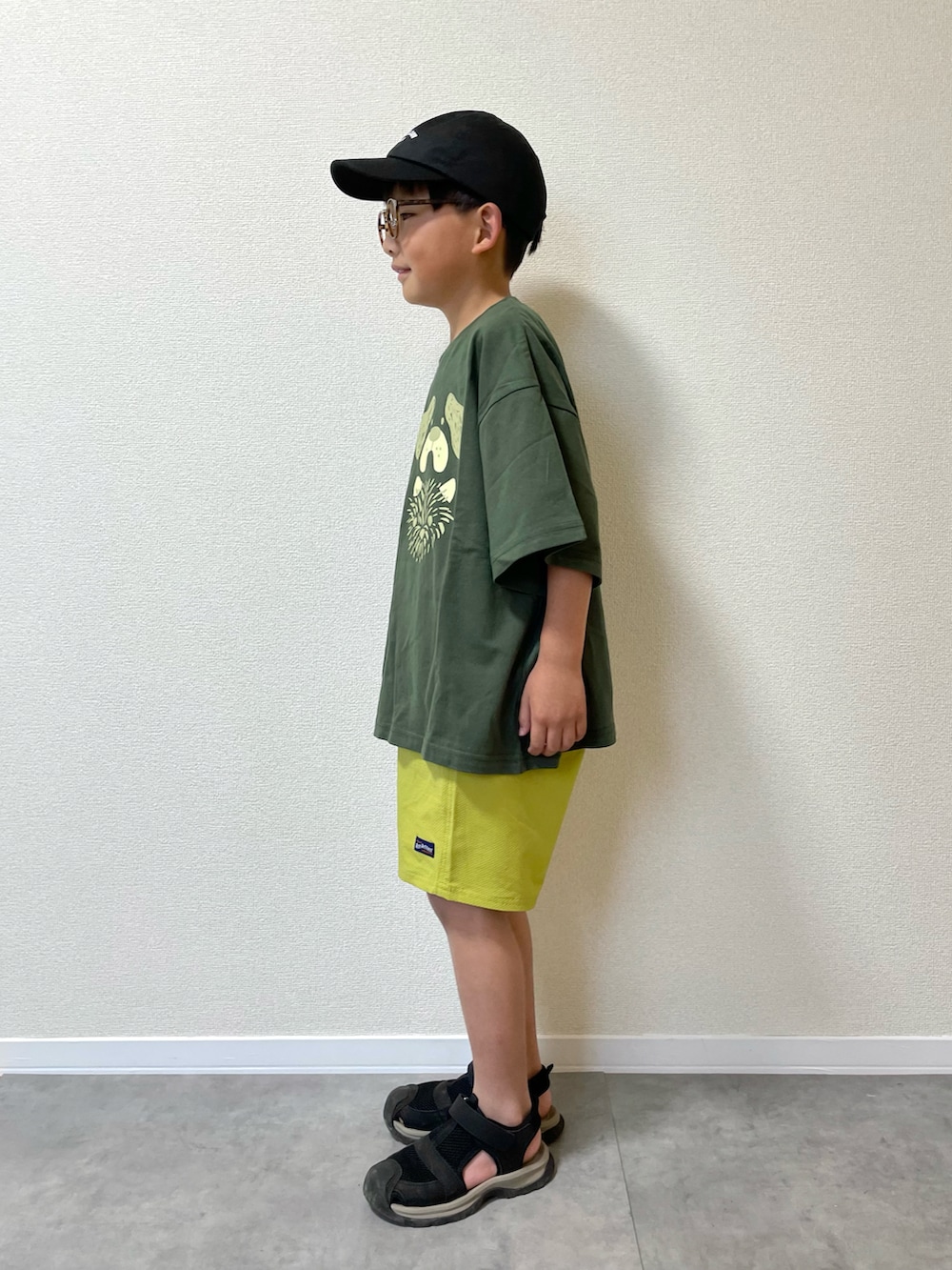 グリーン系のTシャツ/カットソー、イエロー系のその他パンツ、ブラック系のサンダルを着用したキッズの夏コーディネートの2枚目の写真