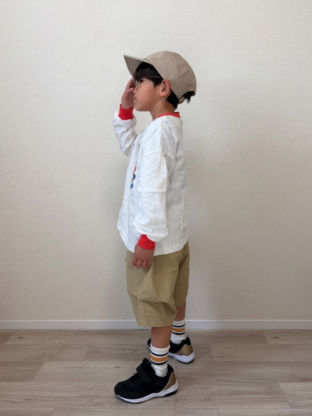 ホワイト系のTシャツ/カットソー、ベージュ系のその他パンツ、ブラック系のスニーカーを着用したキッズの春コーディネートの2枚目の写真