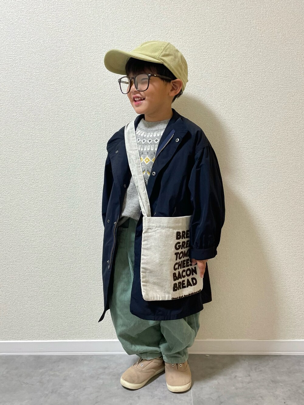 グリーン系のその他パンツ、ベージュ系のショルダーバッグ、グレー系のスニーカーを着用したキッズの冬コーディネートの3枚目の写真