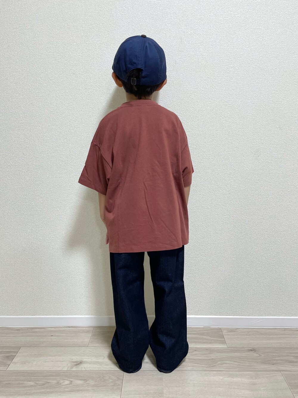 ブラウン系のTシャツ/カットソー、ブルー系のデニムパンツ、グレー系のスニーカーを着用したキッズの秋コーディネートの3枚目の写真