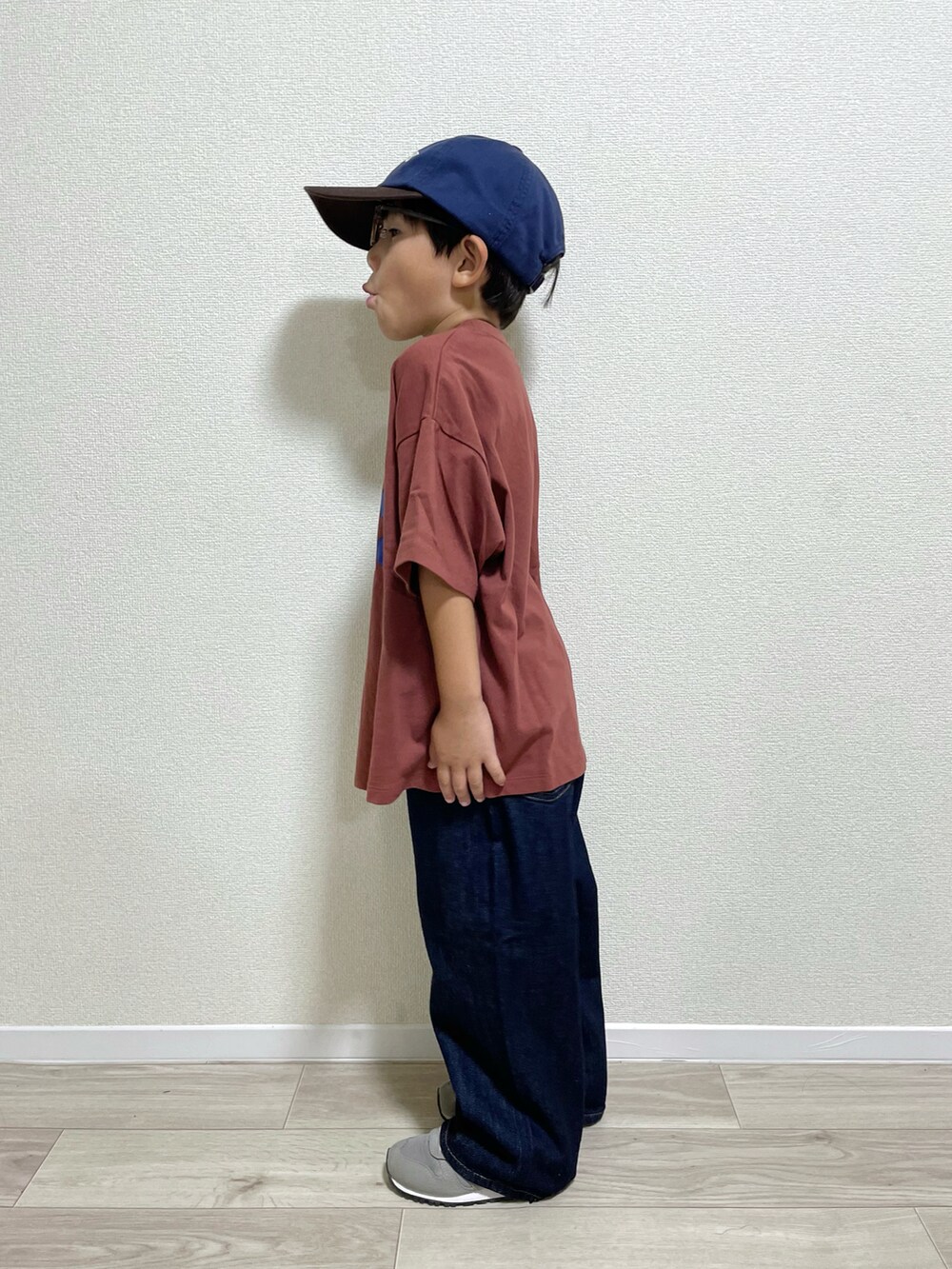 ブラウン系のTシャツ/カットソー、ブルー系のデニムパンツ、グレー系のスニーカーを着用したキッズの秋コーディネートの2枚目の写真