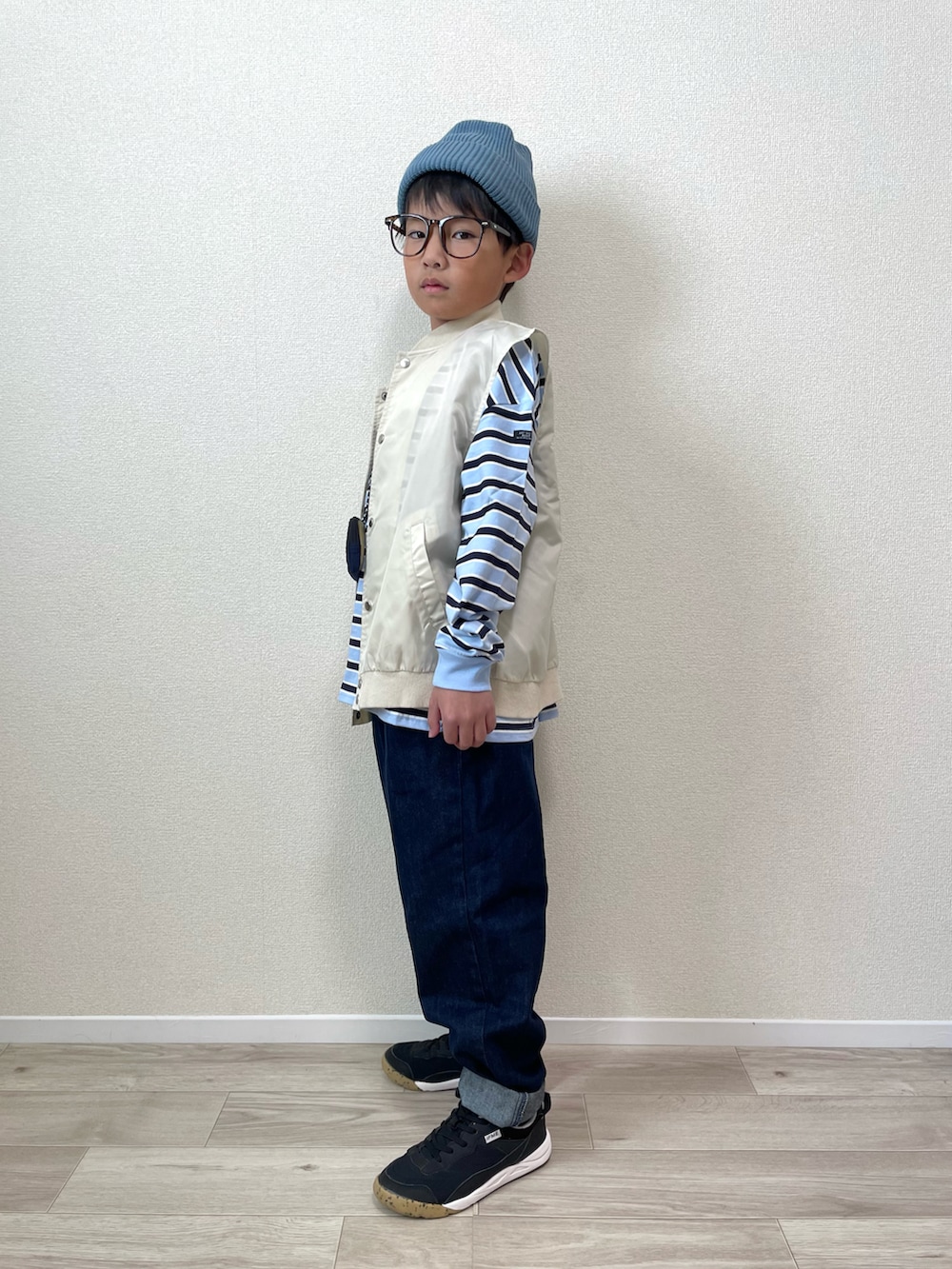 ベージュ系のベスト、ブルー系のTシャツ/カットソー、ブルー系のショルダーバッグを着用したキッズの冬コーディネートの2枚目の写真