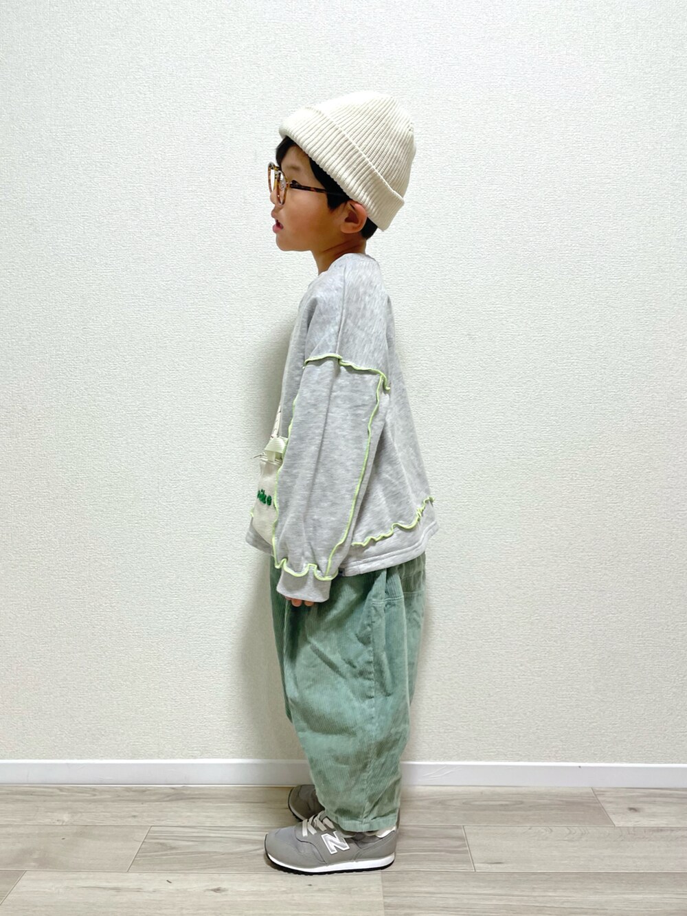 グレー系のスウェット、グレー系のスニーカー、グリーン系のその他パンツを着用したキッズの冬コーディネートの2枚目の写真