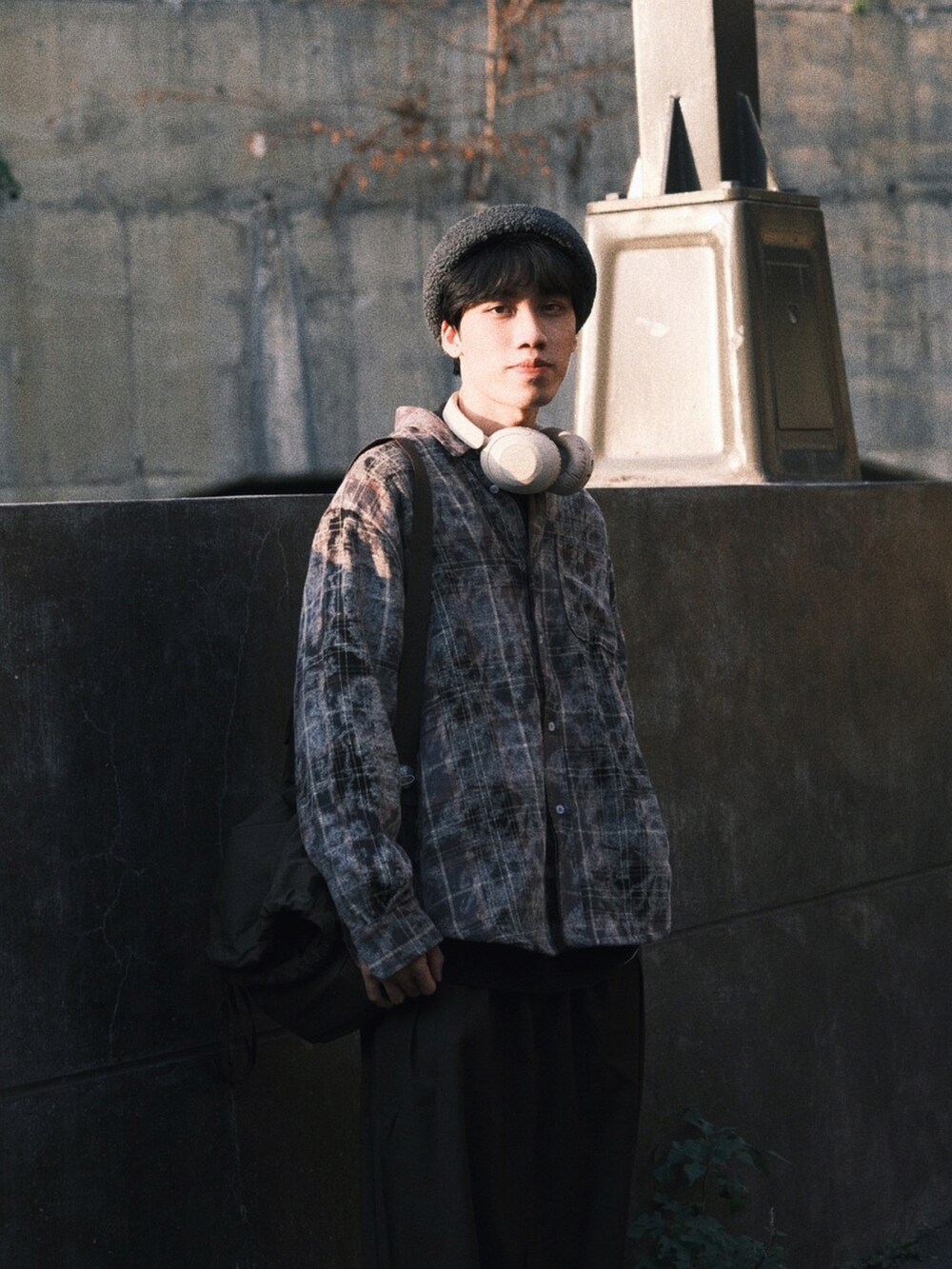 グレー系のシューズ、グリーン系のバッグ、グレー系の帽子を着用したメンズの冬コーディネートの2枚目の写真