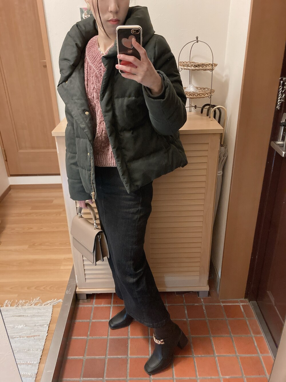 ブラック系のブーツ、ブラック系のデニムスカート、ブラック系のダウンジャケット/コートを着用したレディースの冬コーディネートの4枚目の写真