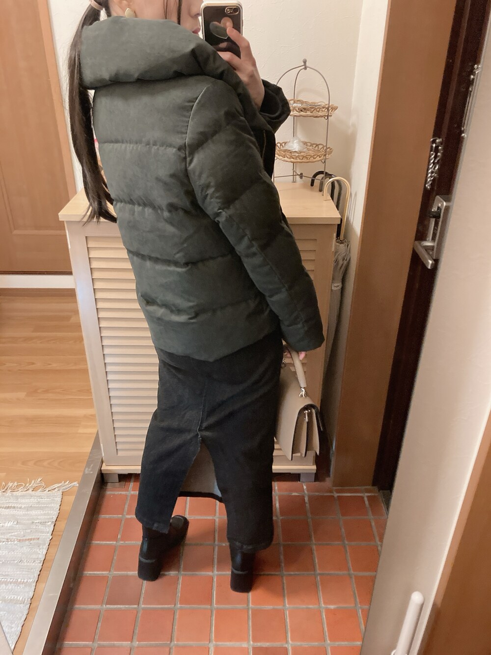 ブラック系のブーツ、ブラック系のデニムスカート、ブラック系のダウンジャケット/コートを着用したレディースの冬コーディネートの3枚目の写真