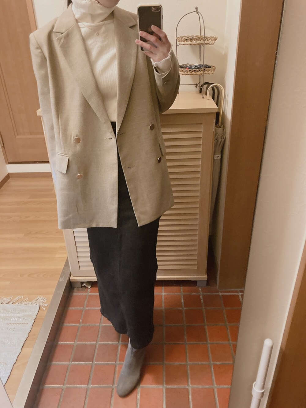 ホワイト系のTシャツ/カットソー、ベージュ系のテーラードジャケット、ブラック系のデニムスカートを着用したレディースの冬コーディネートの2枚目の写真