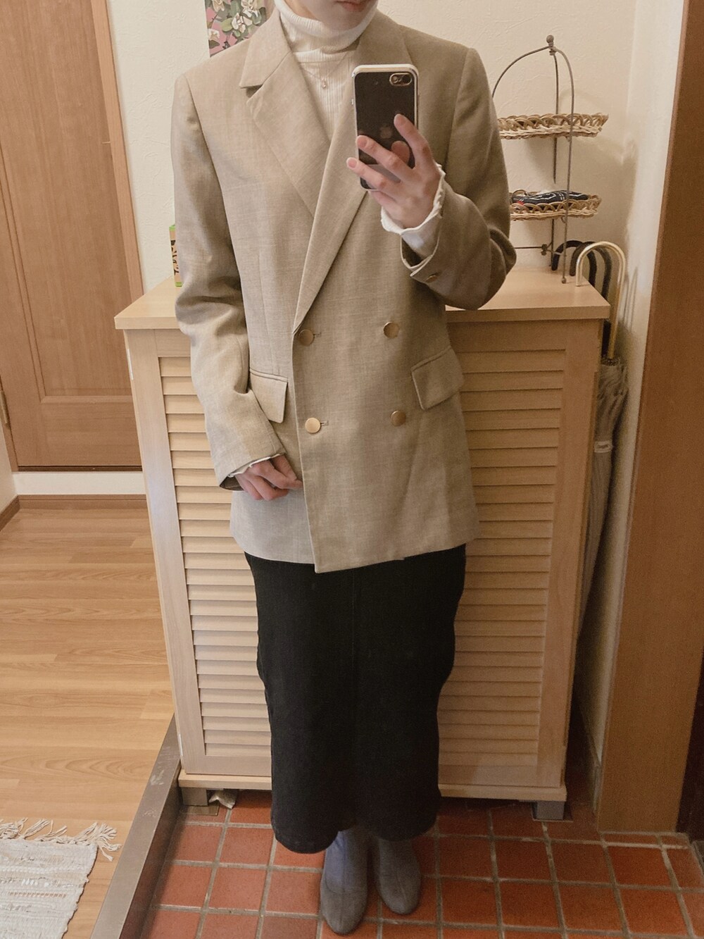 ホワイト系のTシャツ/カットソー、ベージュ系のテーラードジャケット、ブラック系のデニムスカートを着用したレディースの冬コーディネートの3枚目の写真