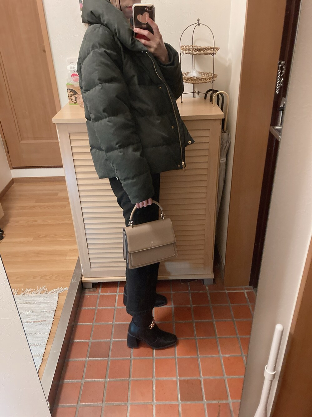 ブラック系のブーツ、ブラック系のデニムスカート、ブラック系のダウンジャケット/コートを着用したレディースの冬コーディネートの2枚目の写真