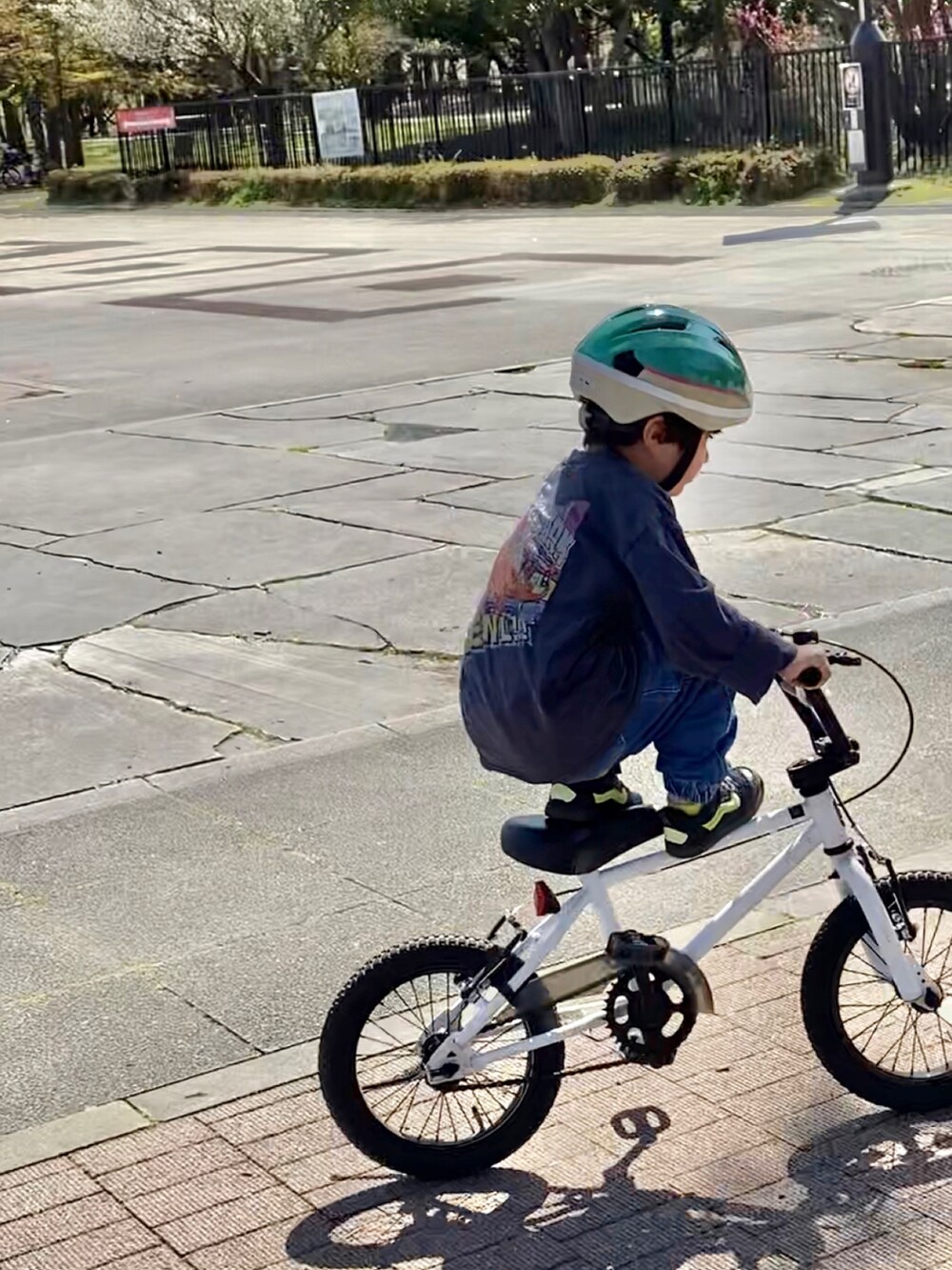 グレー系のTシャツ/カットソー、ブラック系のスニーカー、ブルー系のデニムパンツを着用したキッズの春コーディネートの2枚目の写真