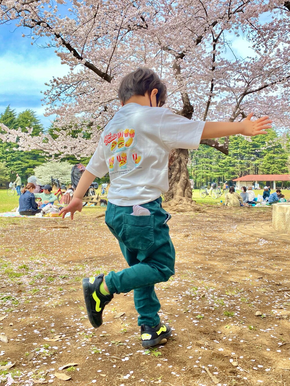 ホワイト系のTシャツ/カットソー、ベージュ系のその他パンツ、ブラック系のスニーカーを着用したキッズの春コーディネートの2枚目の写真